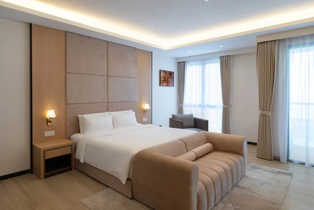 Service suite at Asteria Melaka with the bed facing a full-height window.